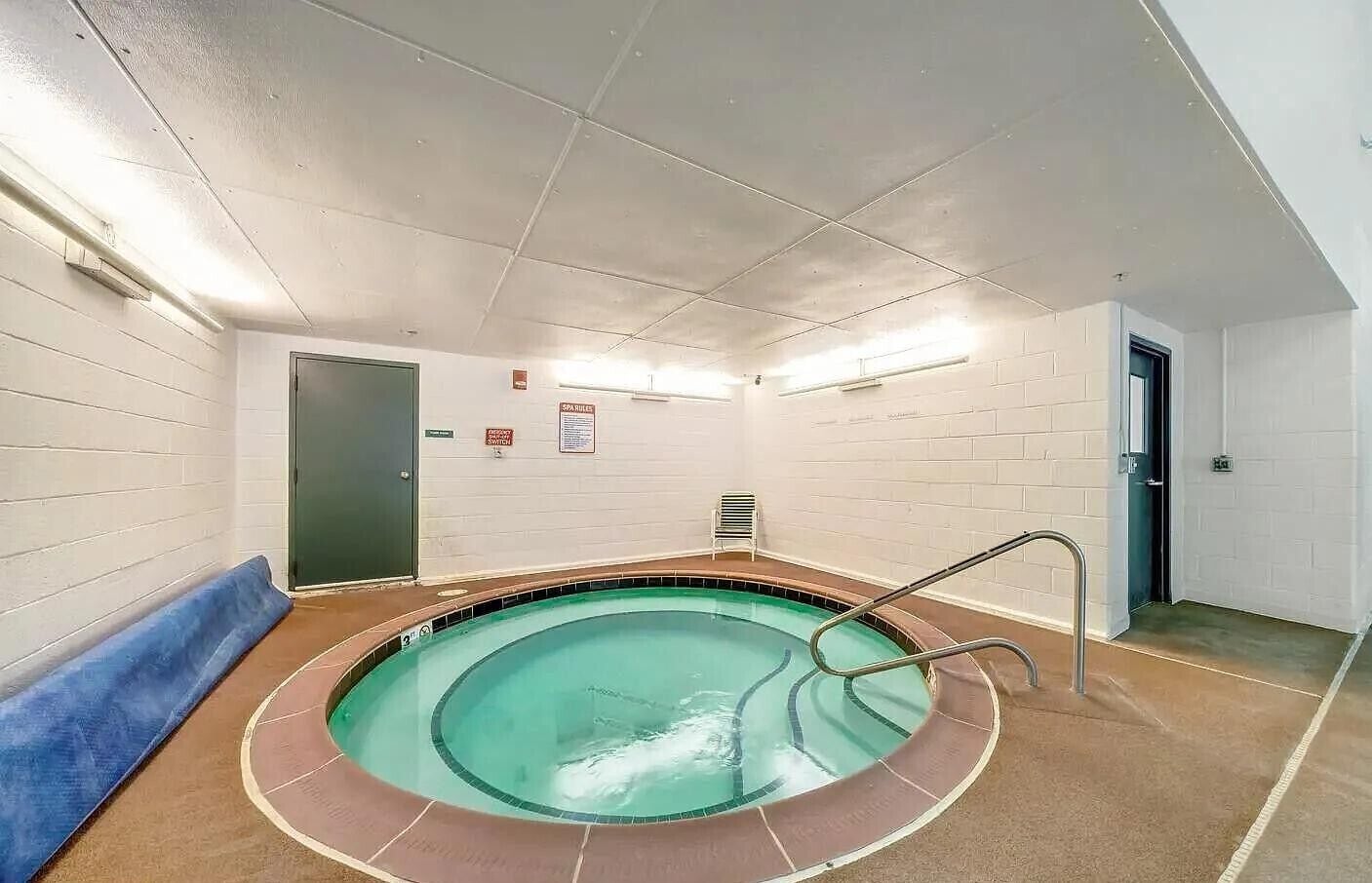 A spa pool with a circular design, a bench, and a door.