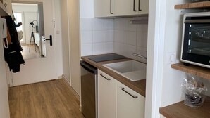 Eine moderne Küche mit weißen Schränken, einer Holz Arbeitsplatte und einem eingebauten Ofen.