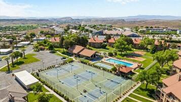 Un quartier résidentiel doté d’un grand court de tennis, d’une piscine et entouré de maisons.