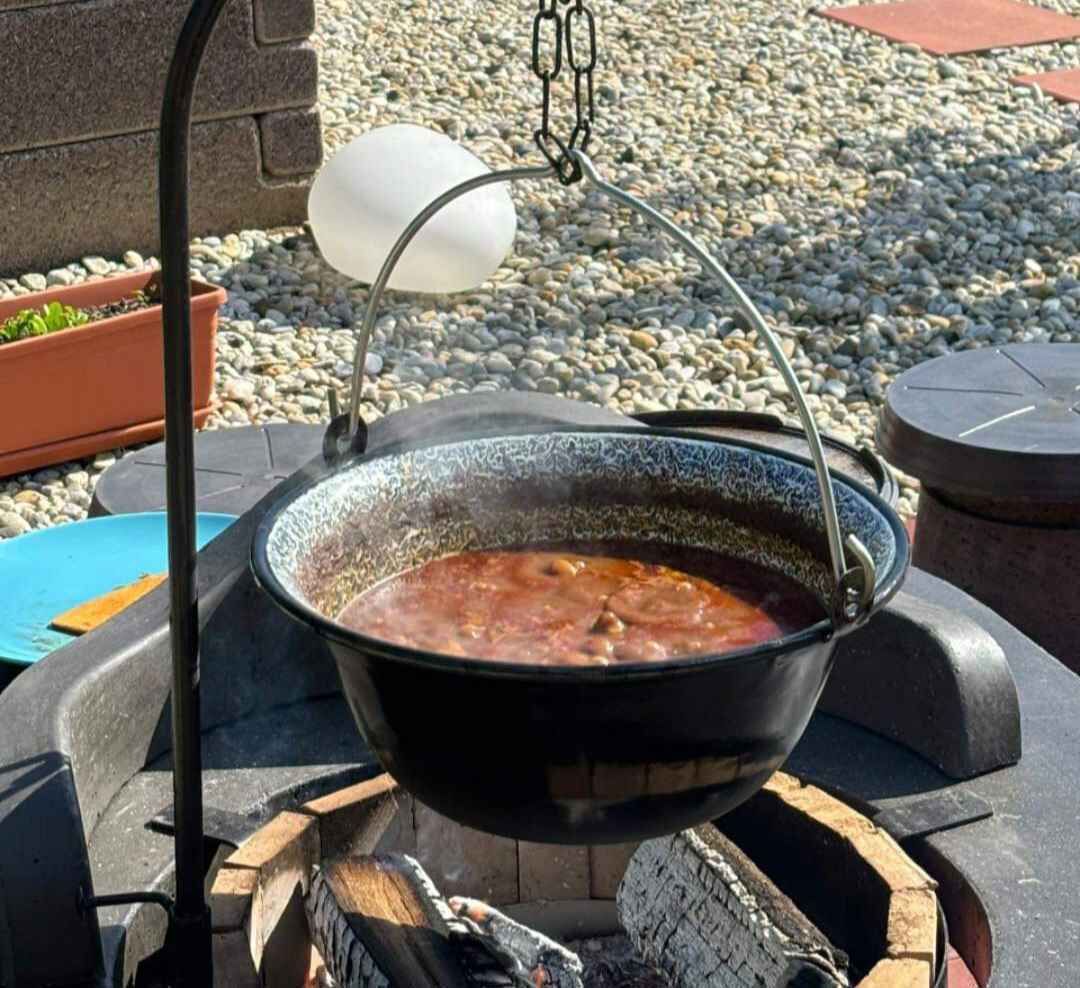 Equipo de cocina portátil que incluye una olla sobre un soporte, una luz colgante y un brasero.