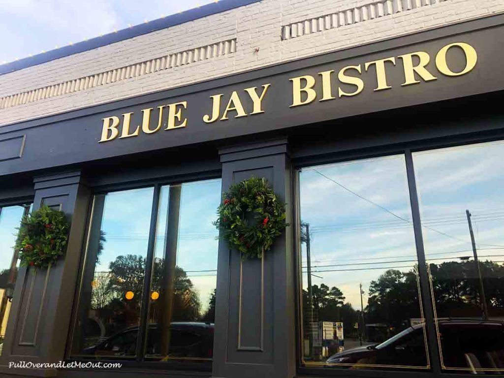 The exterior of Blue Jay Bistro with large windows and wreath decorations.