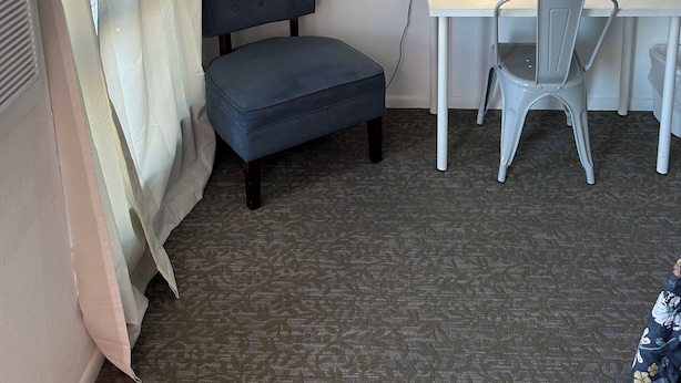 Una habitación de hotel con cama, escritorio, silla, lámpara y un cuadro en la pared.