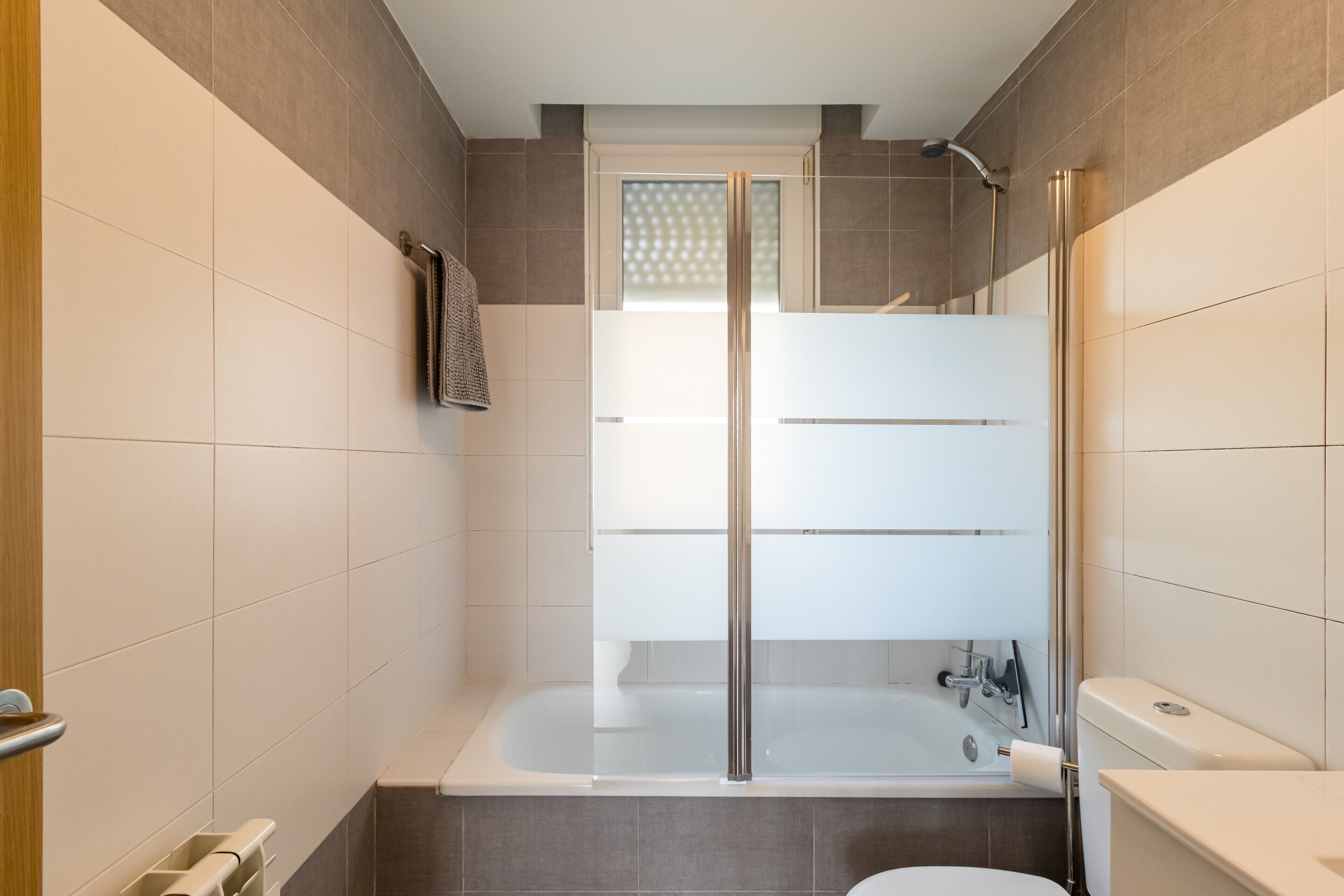 Un baño moderno con cabina de ducha de vidrio, bañera y retrete.