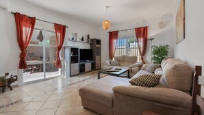 A living room with a sofa, coffee table, and curtains.