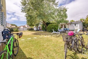 A backyard with a bicycle, a small house, and outdoor furniture.