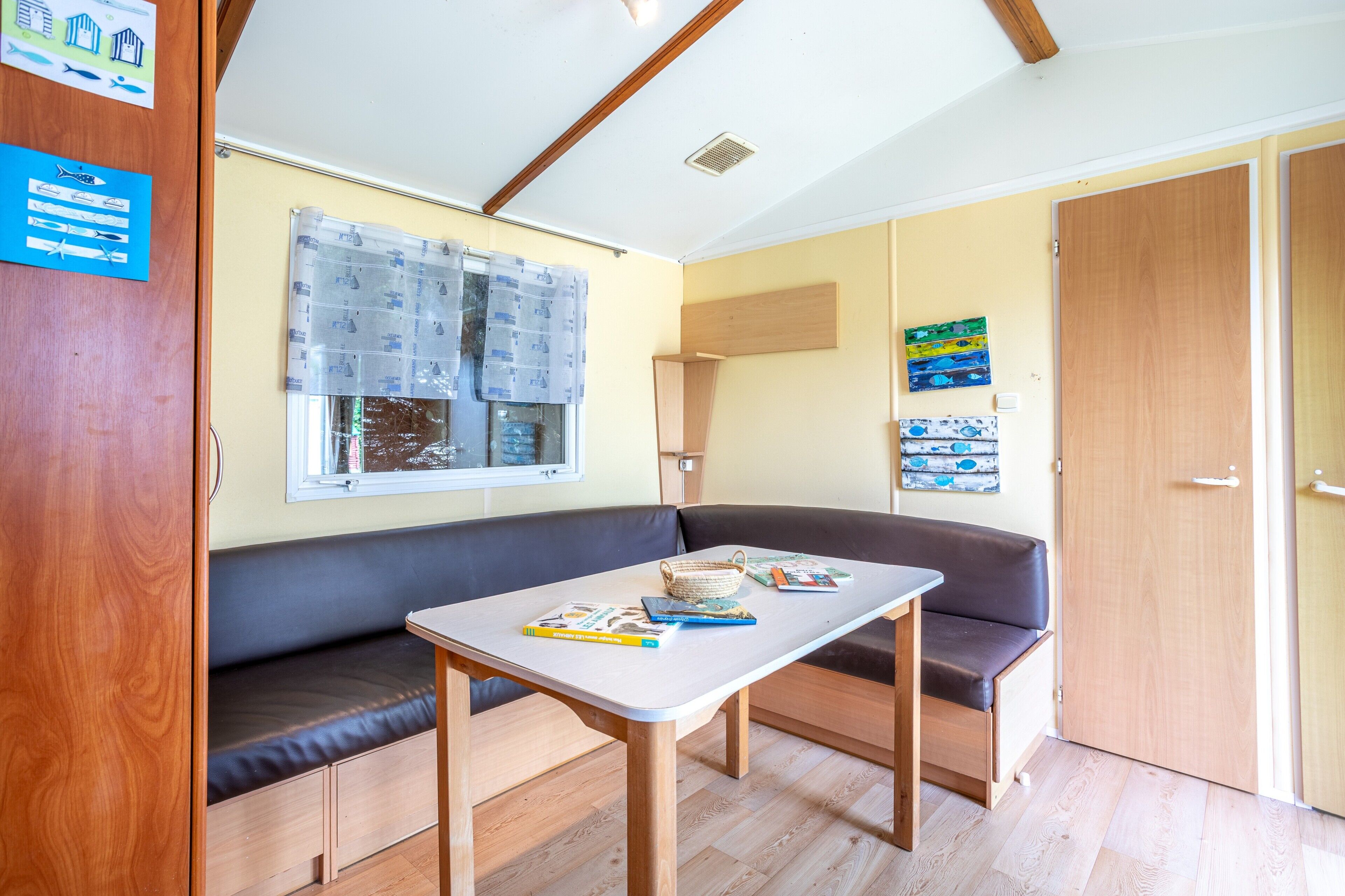 A compact room with a bench, a table, and a window with blinds.