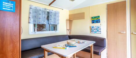 A compact room with a bench, a table, and a window with blinds.