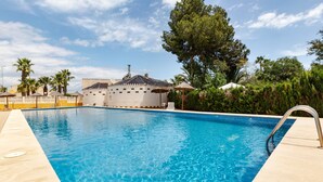 A swimming pool with a clear blue water surface, surrounded by a light-colored deck. - Villa 'Artep' with Shared Pool, Wi-Fi and Air Conditioning (Cartagena)