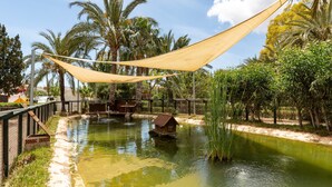 A water feature with a houseboat, surrounded by palm trees and a hammock. - Villa 'Artep' with Shared Pool, Wi-Fi and Air Conditioning (Cartagena)
