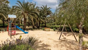 A playground with a slide, swings, and a bench. - Villa 'Artep' with Shared Pool, Wi-Fi and Air Conditioning (Cartagena)