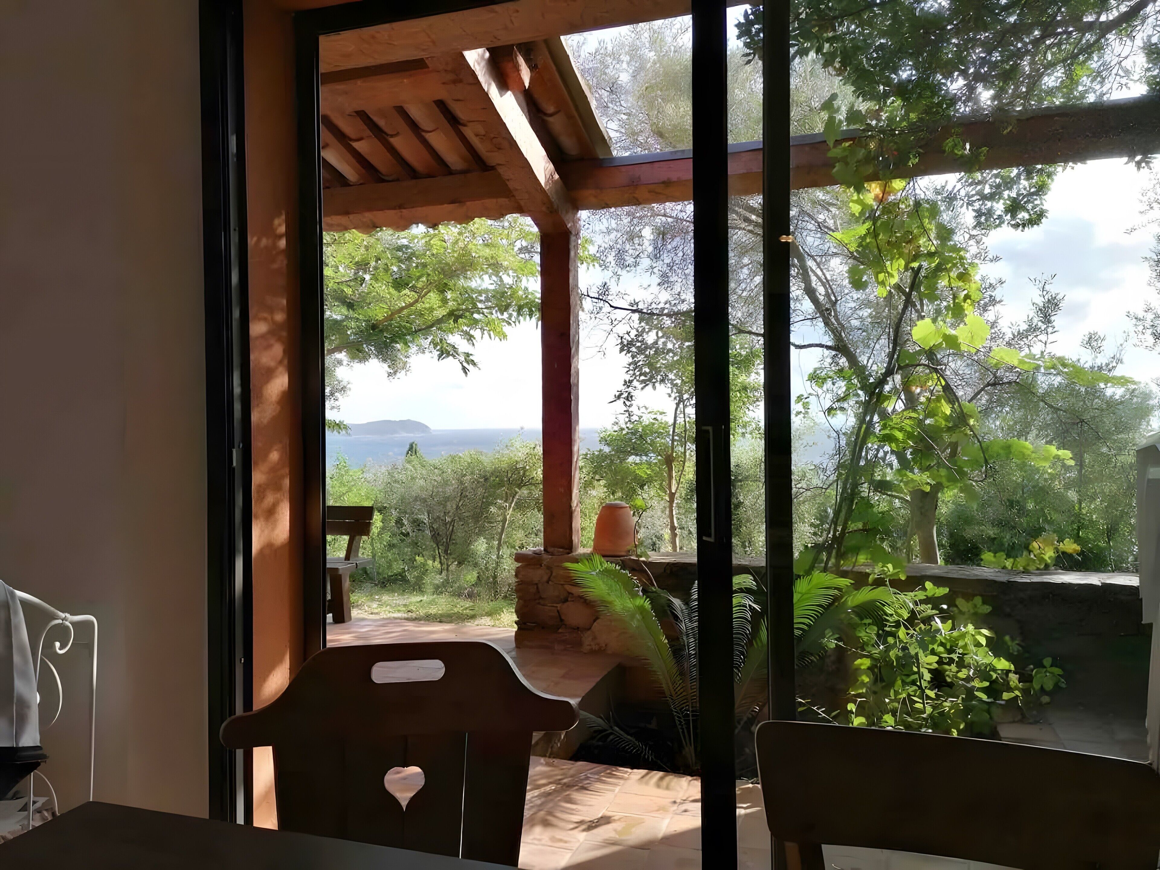 A room with a view of a garden and a distant landscape.