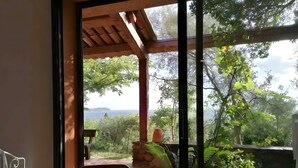 A room with a view of a garden and a distant landscape.