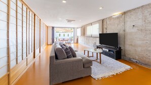 A modern living room with a sofa, TV, and a dining area in the background. - Apartment 'Casa Azahar' with Private Pool, Wi-Fi, and Air Conditioning (Níjar)