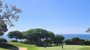 Ein Golfplatz mit Blick auf das Meer.