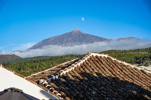 A mountain with a moon, a forested valley, and a tiled roof. - Vacation 'Casa Guimar' with Sea View, Wi-Fi and Air Conditioning (Tanque)