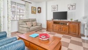 A living room with a sofa, a coffee table, a TV, and a cabinet.