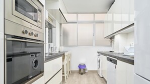 Una cocina moderna equipada con lavadora, horno y lavavajillas integrados.