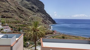 Un paysage côtier avec une falaise abrupte, une route et une vue sur l’océan.