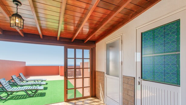 A covered outdoor area with a wooden ceiling, a sliding glass door, and a view of the sky. - Vacation 'Candelaria 1' with Sea View, Wi-Fi and Air Conditioning (Candelaria)