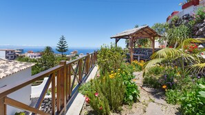 A garden with a wooden fence, a gazebo, and a view of the sea. - Vacation Home 'Volcán 18' with Sea View, Private Terrace and Wi-Fi (El Tanque)