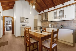 A kitchen with wooden cabinets, a dining table, and chairs.