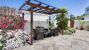 A patio area with a pergola, wicker furniture, and potted plants. - Vacation Home 'Volcán 16' with Private Terrace, Private Garden and Wi-Fi (El Tanque)