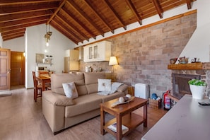 A cozy living area with a sofa, a wooden table, and a fireplace.