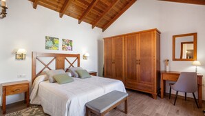 A bedroom with a wooden ceiling, a bed with a headboard, a wardrobe, a desk with a chair, and a mirror. - Vacation Home 'Volcán 16' with Private Terrace, Private Garden and Wi-Fi (El Tanque)