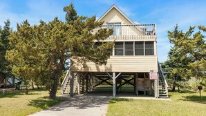 A two-story wooden structure with a balcony, a staircase, and a sign indicating it is a museum. - Short Walk To The Beach, Water Views, Screened in Porch, Sun Deck (Salvo)