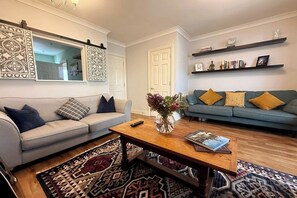 Relax in this stylish living room with a sofa, coffee table, and bookshelves.