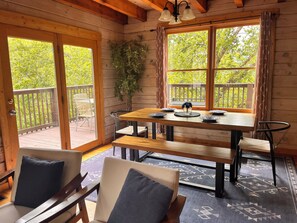 A wooden cabin with a dining table, benches, and chairs.