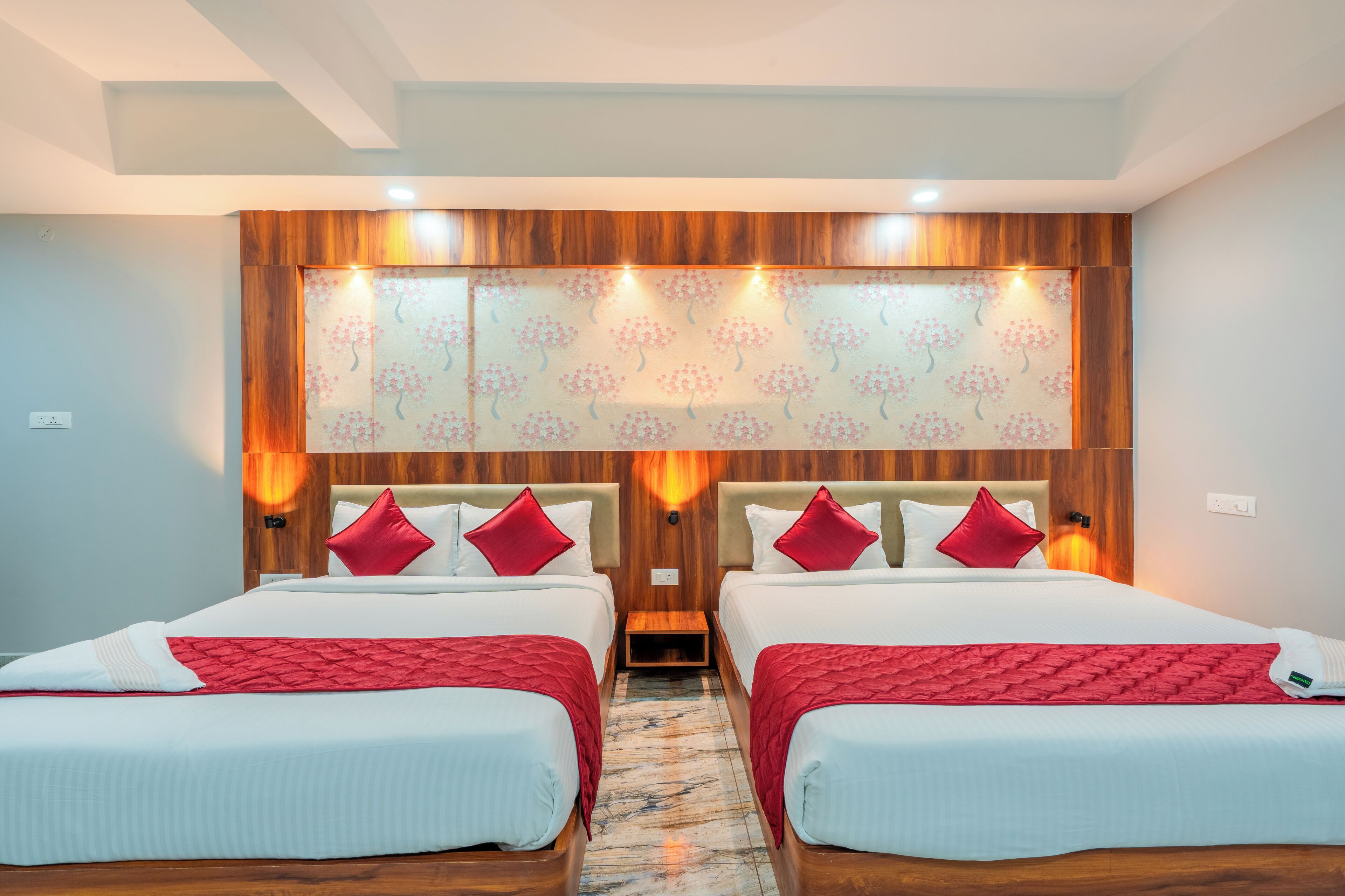 A hotel room with two beds, wooden headboards, and a decorative wall panel.