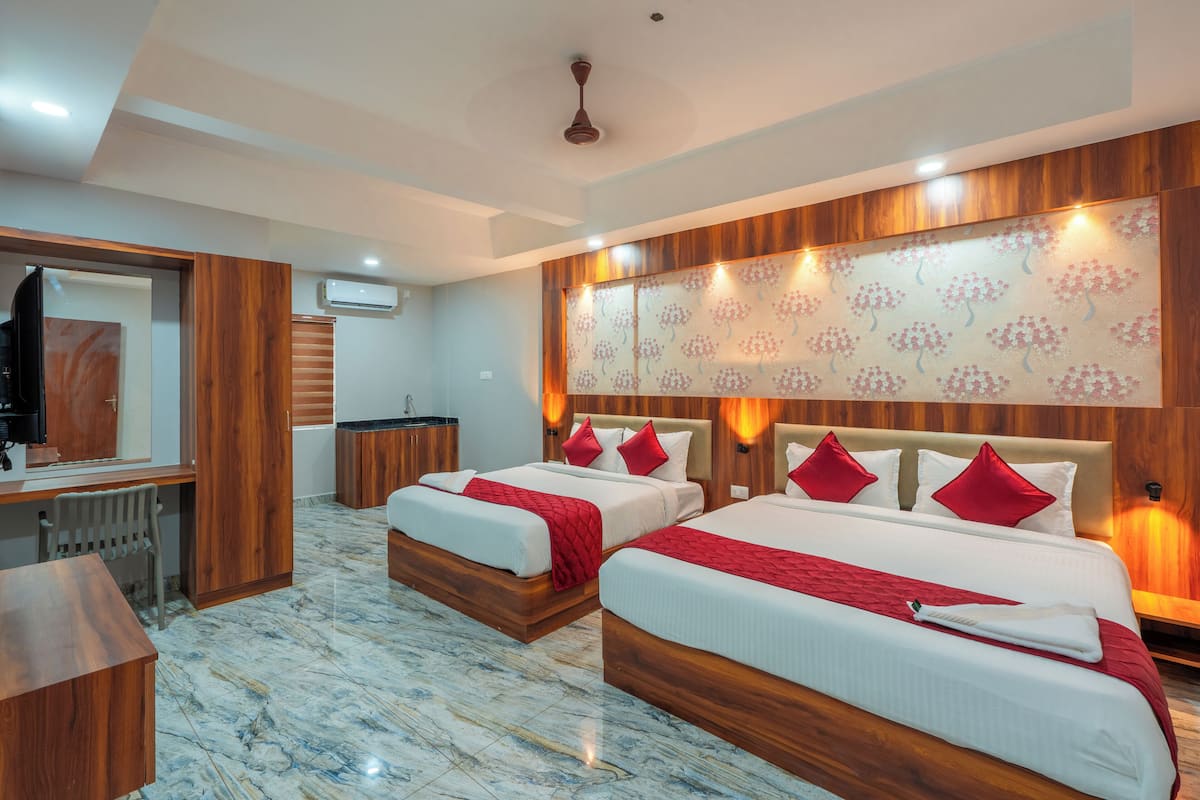 A hotel room with two beds, a desk, and a mirror.