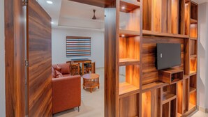 Un salon moderne avec un meuble TV en bois, un canapé et un coin repas.