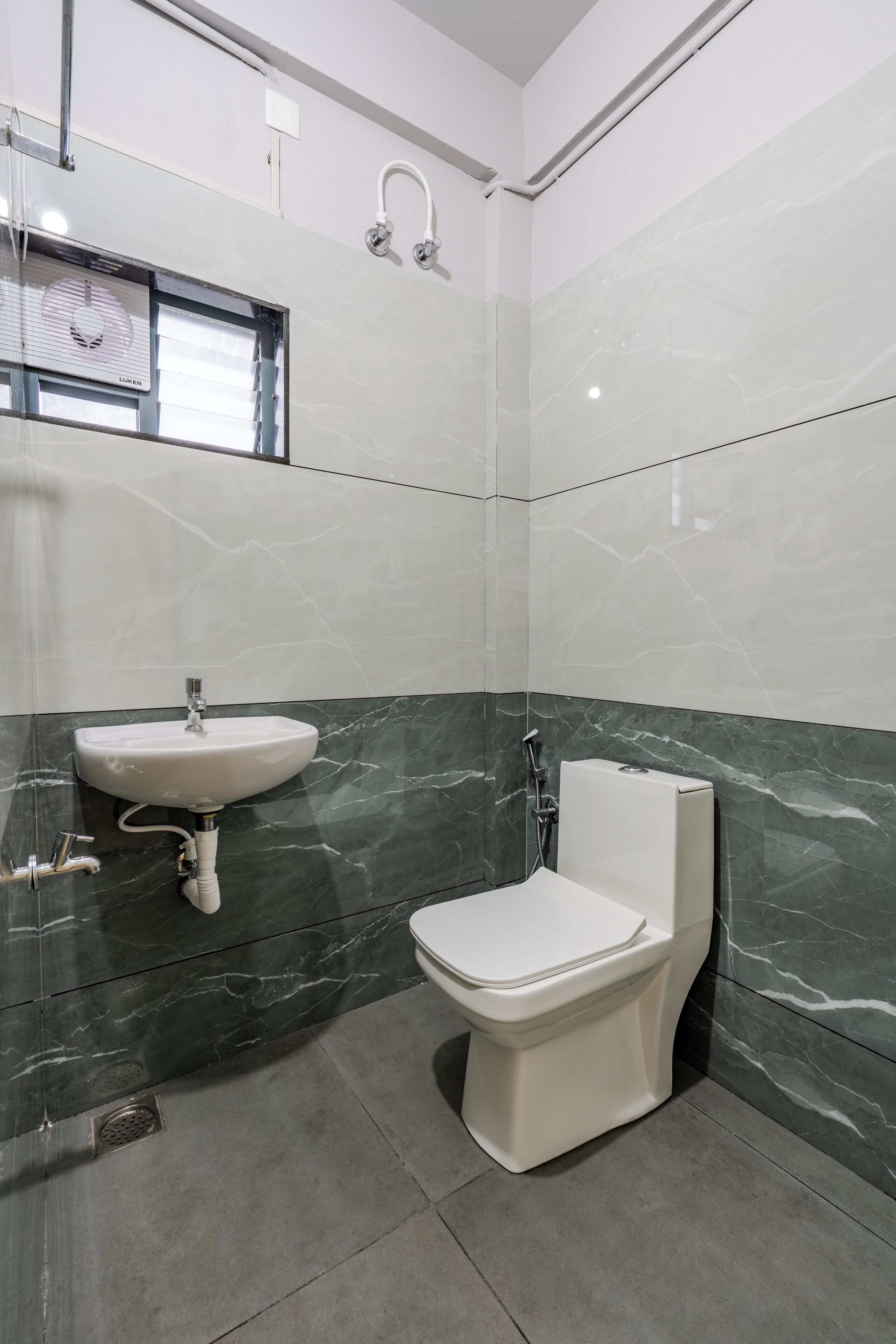 A modern bathroom with a white sink, toilet, and shower.
