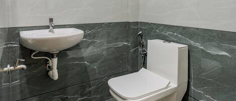 A modern bathroom with a white sink, toilet, and shower.