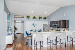Enjoy cooking in this kitchen with a central island, bar stools, and dark cabinetry.