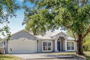 Stunning home with a garage and a large tree in the front yard.