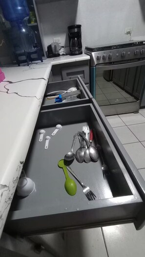 Een magnetron, een oven, kookgerei, borden en bestek