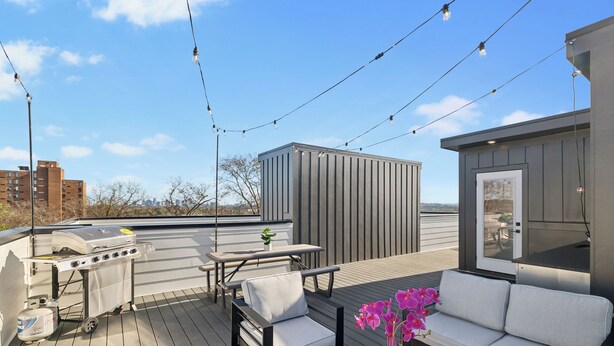 An outdoor deck with a grill, seating area, and string lights. - Nashville Rooftop Oasis! 8 min Broadway. Sleeps 12 (Nashville)