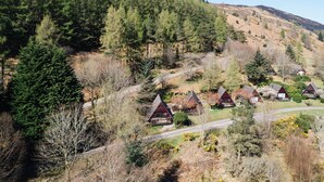 Un groupe de chalets, avec une colline boisée en arrière-plan.