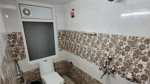 Une salle de bain avec des toilettes, une douche et un lavabo.