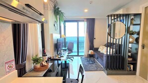 Een moderne woonkamer met een eetgedeelte, een televisie en een balkon met uitzicht.