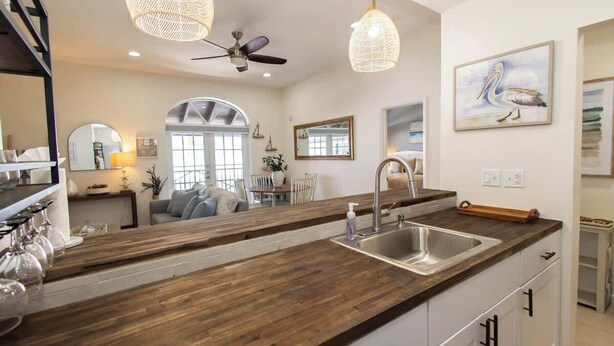 A kitchen with a wooden countertop, a sink, and pendant lights. - Sandbar Suite | 2 bed near Duval & waterfront (Key West)