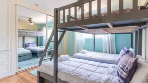 Een slaapkamer met stapelbedden, een spiegelkast en uitzicht op de omgeving.