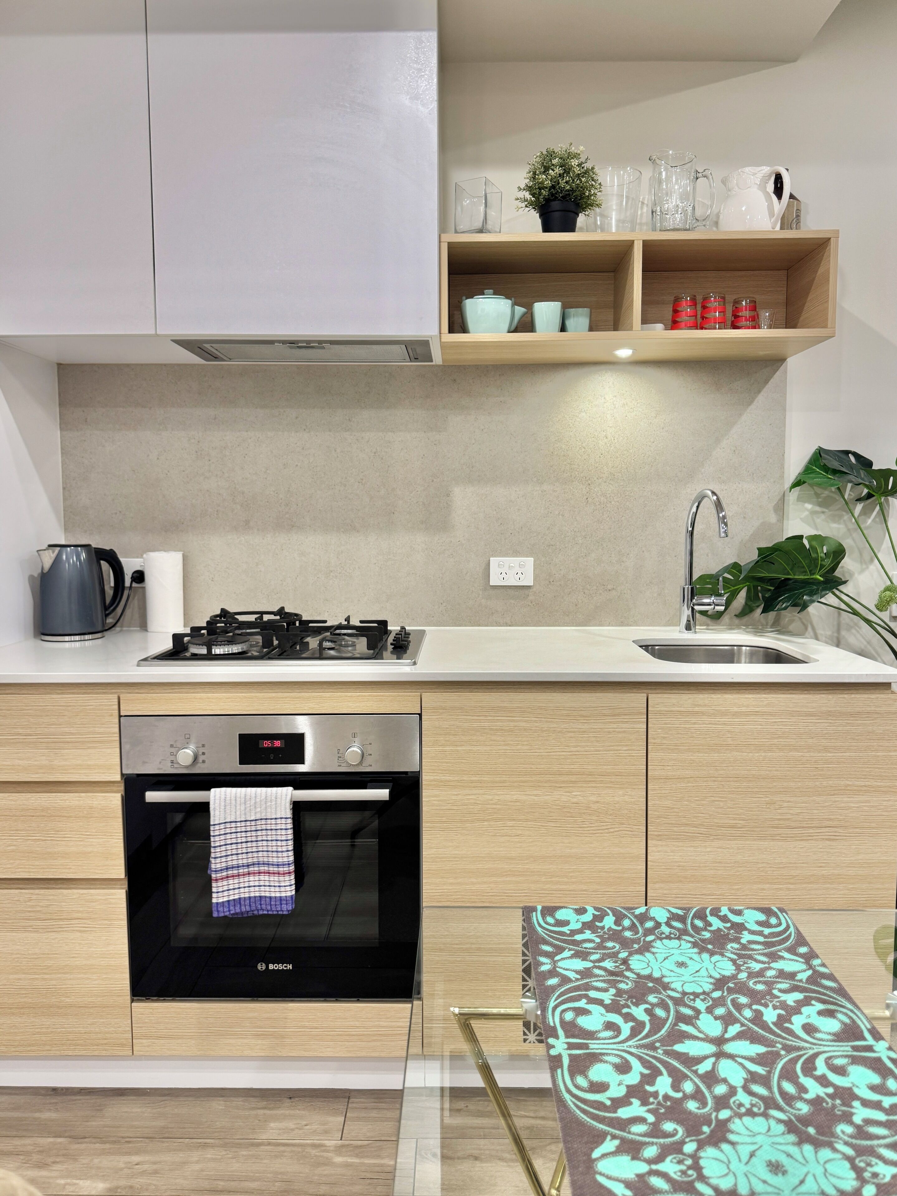 Una cocina moderna con horno empotrado, estufa a gas, pileta y encimera de madera.