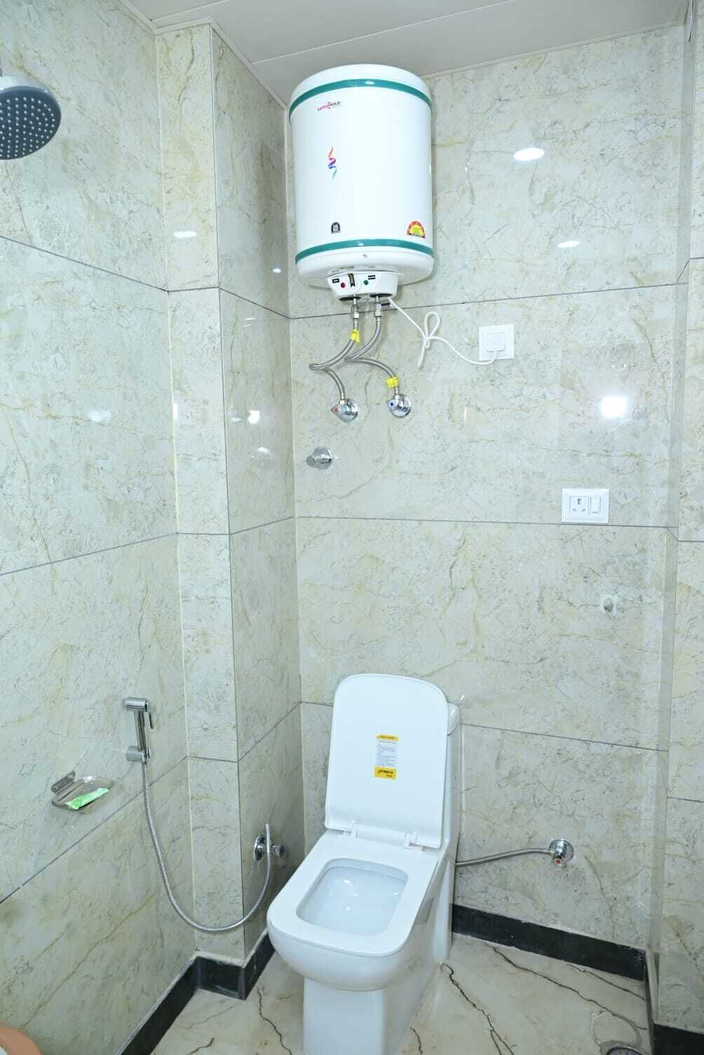 A bathroom with a toilet, a shower, and a water heater.