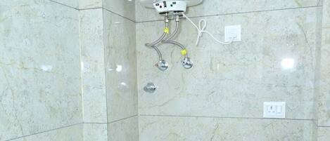 A bathroom with a toilet, a shower, and a water heater.