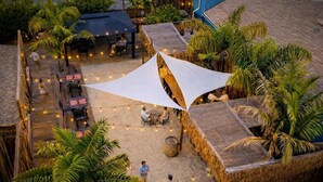 An outdoor area with thatched-roof structures, string lights, and palm trees. - Spacious Private Retreat with Event Spaces (San Diego)