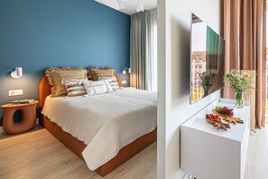 Ein modernes Schlafzimmer mit Bett, Nachttisch, Fernseher und Fenster mit Blick.